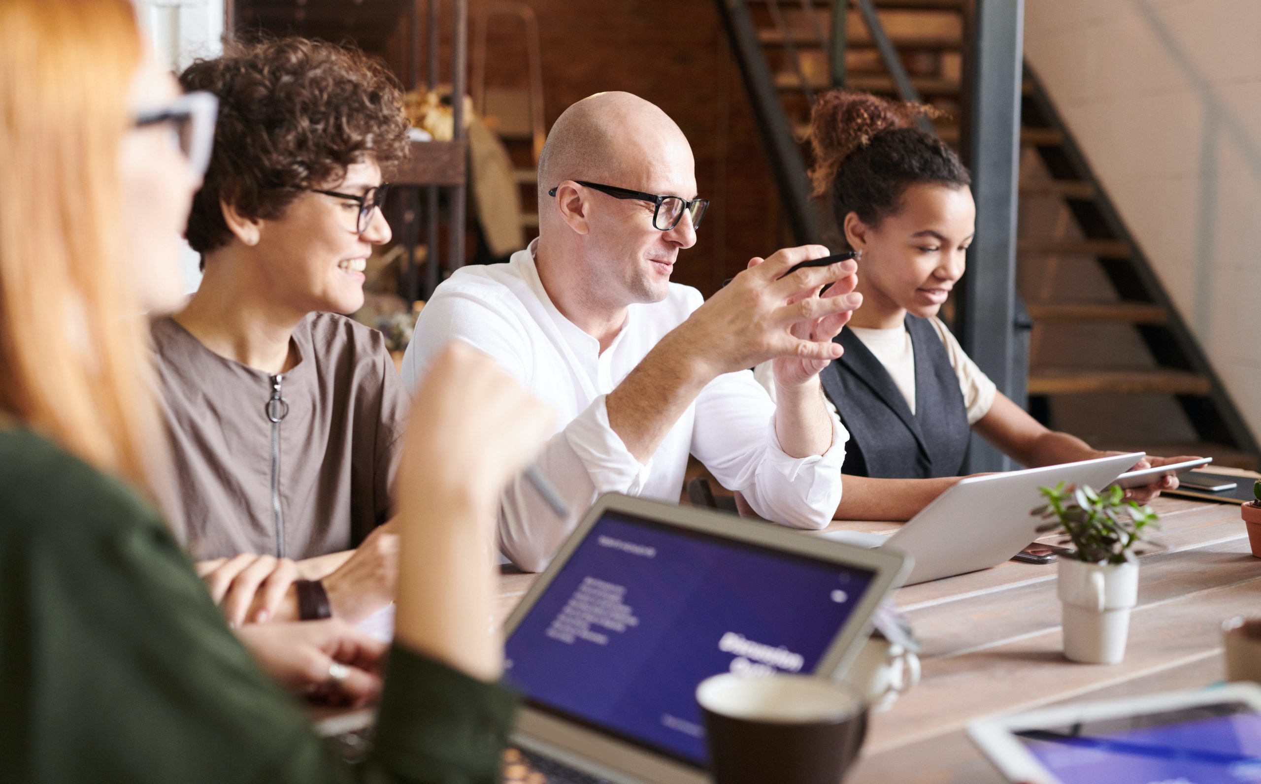 4 people at a table working on computers