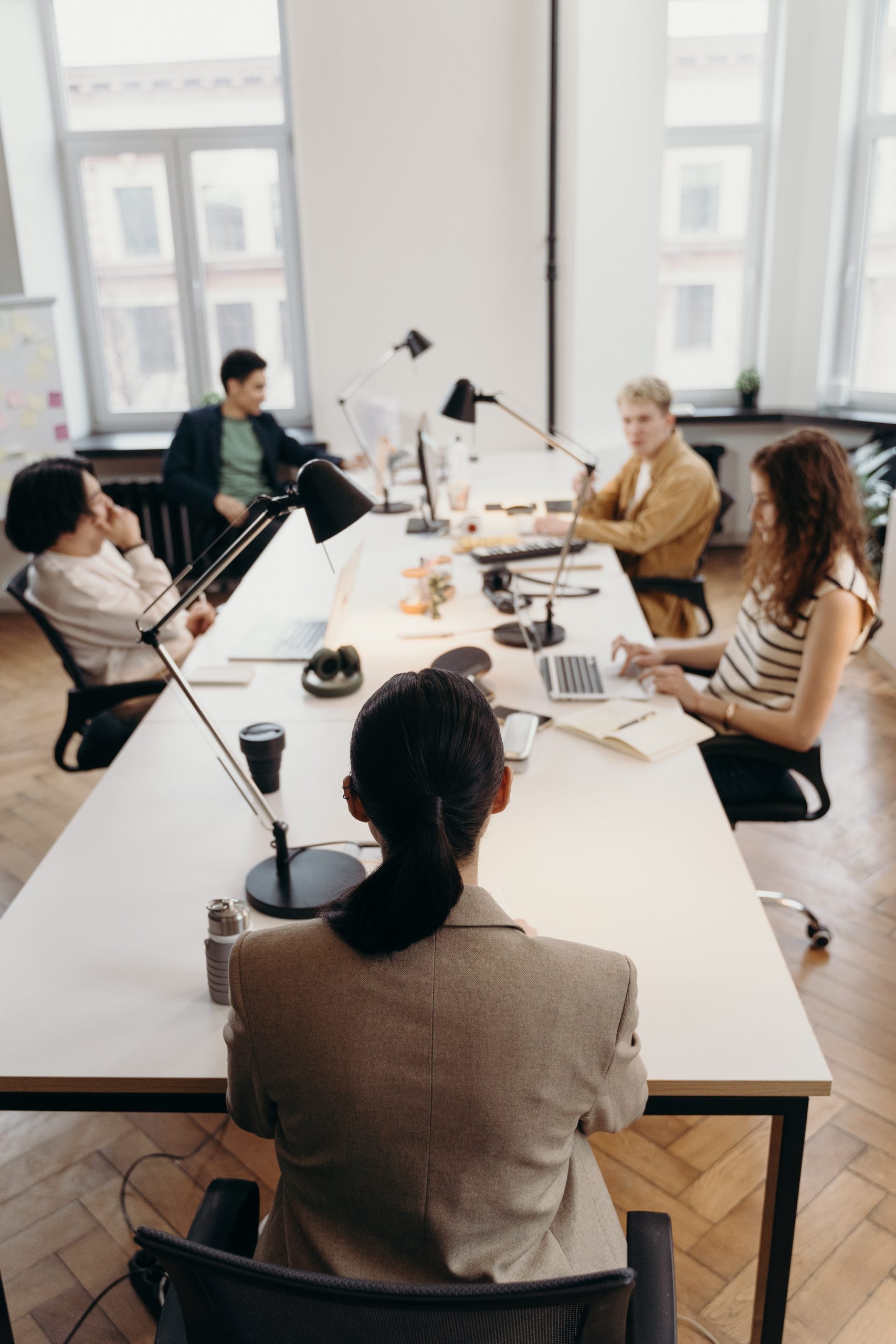 people sitting around a boardroom table talking