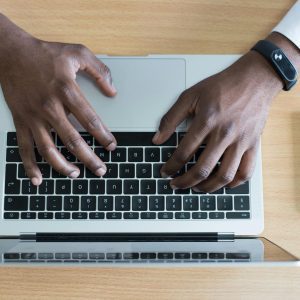 A pair of hands typing on a laptop