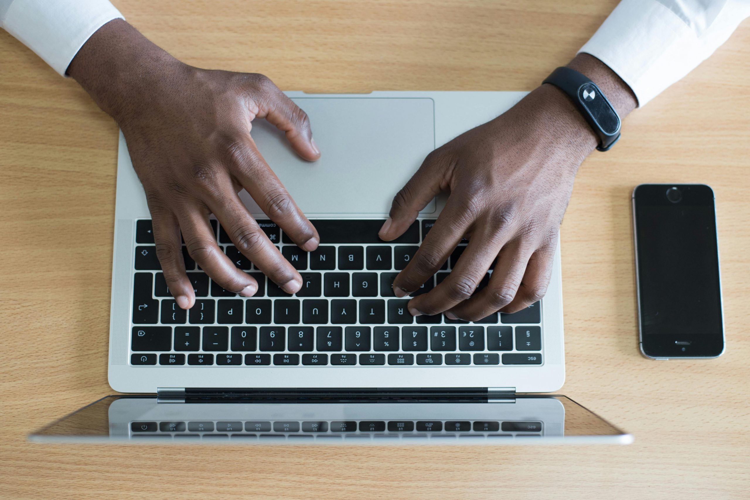 A pair of hands typing on a laptop