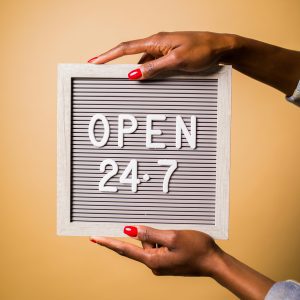Hands holding an Open 24-7 Sign