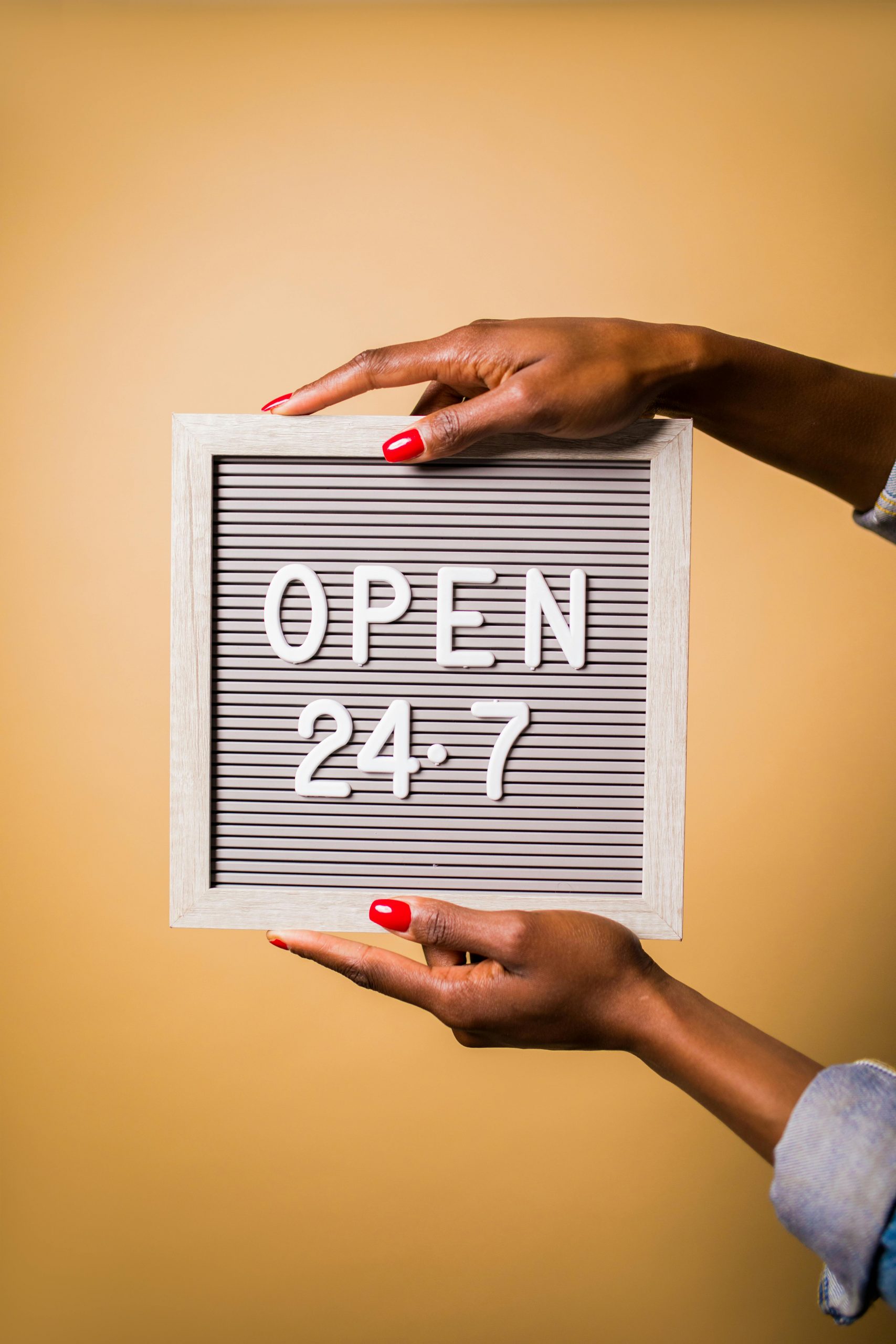 Hands holding an Open 24-7 Sign